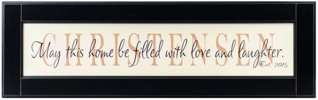 Personalized Wood Framed Sign. Off white wood sign with tan family name framed in black wood frame with saying "May this home be filled with love and laugher", and established date in black