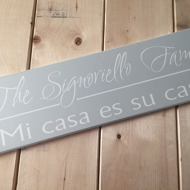 Established Sign in Spanish. Black wood sign with family name and established year in tan with text 